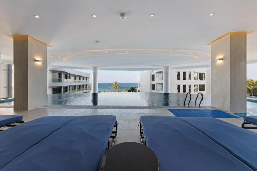 富国Sunset Beach Resort and Spa的一间设有两张蓝色桌子的房间和一个游泳池