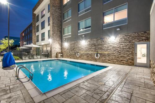艾迪生Holiday Inn Express & Suites Dallas North - Addison, an IHG Hotel的大楼前的游泳池