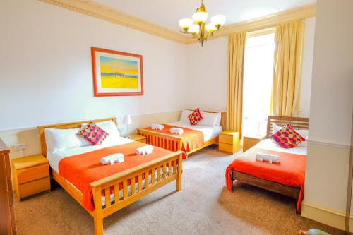 爱丁堡巴尔莫尔宾馆的酒店客房,设有两张床和一张沙发