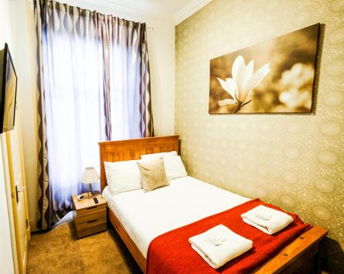 爱丁堡巴尔莫尔宾馆的卧室配有一张带红色毯子的白色床