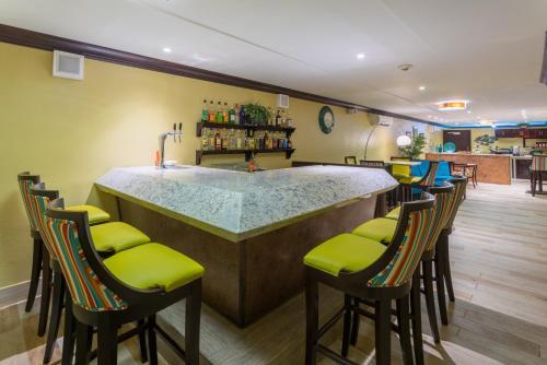 蒙特哥贝Holiday Inn Resort Montego Bay All-Inclusive, an IHG Hotel的酒吧设有绿色软垫凳子和柜台