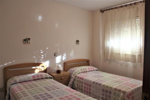 托里代巴拉拉磨家蒙特科所公寓的一间卧室设有两张床和窗户。