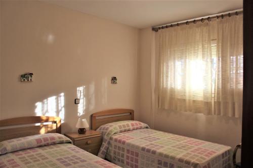 托里代巴拉拉磨家蒙特科所公寓的一间卧室设有两张单人床和一个窗户。
