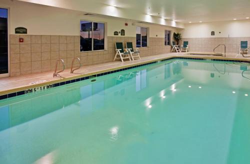 威奇托威奇塔机场快捷假日&套房酒店的酒店内有一个蓝色的游泳池