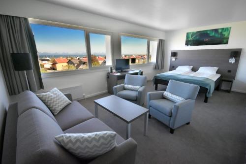 安德内斯Thon Partner Hotel Andrikken的酒店客房带两张床、一张沙发和椅子。