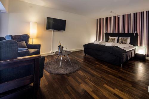 卡尔马威特第一酒店的一间卧室配有一张床、一张沙发和一台电视。