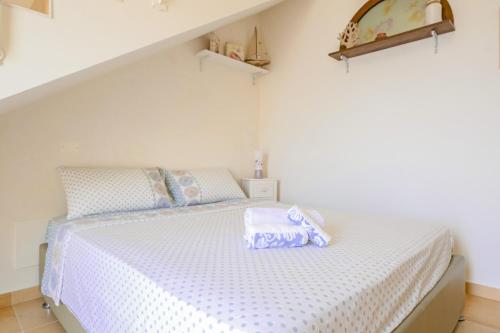 加利亚诺德尔卡波Una Torre nel Mare的一间卧室配有一张铺有紫色和白色床单的床