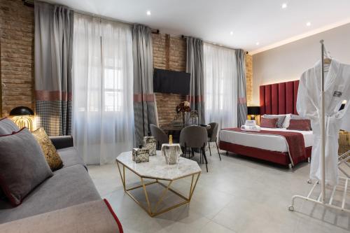 格拉纳达BiBo Suites Plaza Nueva的酒店客房,配有床和沙发