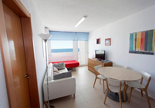 马塔拉斯卡尼亚斯Apartamento con vistas al mar primera linea playa Matalascañas的一间带桌子的房间和一间带卧室的房间