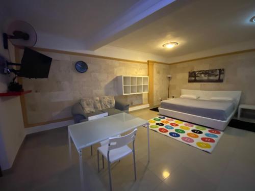 圣佩德罗-德马科里斯呱啦呱公寓式酒店的一间卧室配有一张床、一张桌子和一张沙发