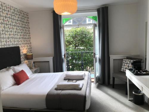 布莱顿霍夫白屋旅馆的一间卧室设有一张床和一个大窗户