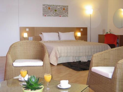 尼科西亚阿莱格拉GSP体育中心酒店的一间卧室配有一张床、两把椅子和一张桌子