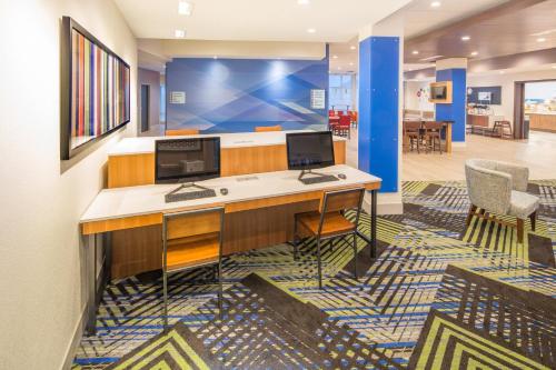 WhitestownHoliday Inn Express & Suites - Indianapolis NW - Zionsville, an IHG Hotel的办公室,桌子上有两个电脑显示器