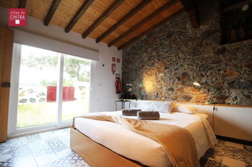 辛特拉辛特拉别墅的一间卧室设有一张大床和石墙