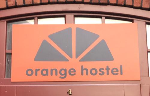托伦橙色旅舍的建筑物窗户上的橙色医院标志