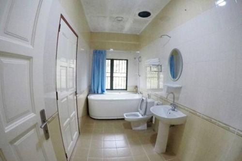 昆达桑Bonsai Villa @ Mesilou 盆栽小苑的浴室配有盥洗盆、卫生间和浴缸。