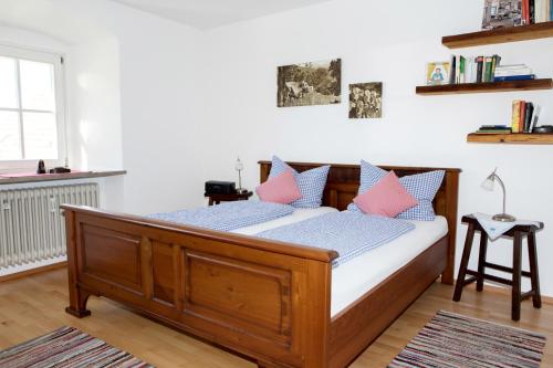 阿尔戈伊地区伊斯尼Ferienwohnung Karin Bucher的一间卧室配有带粉色和蓝色枕头的木床