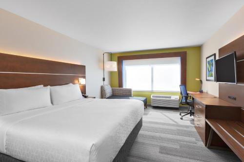 Union GapHoliday Inn Express & Suites - Union Gap - Yakima Area, an IHG Hotel的酒店客房设有一张大床和一张书桌。