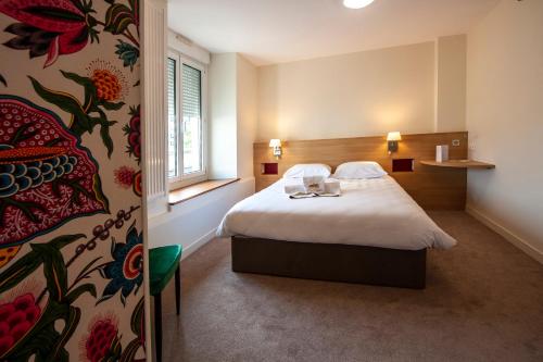 昂热博帕斯图尔旅馆的酒店客房设有床和窗户。