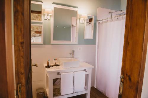 卡梅隆El Legado Wine Lodge的白色的浴室设有水槽和淋浴。