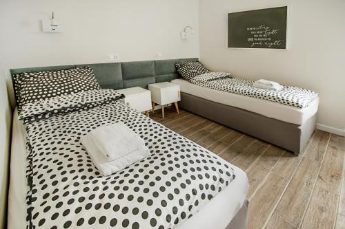 皮瑟兹诺Apartament Centrum XL - Komfortowe Noclegi的一间卧室配有两张床,配有黑白的波尔卡点