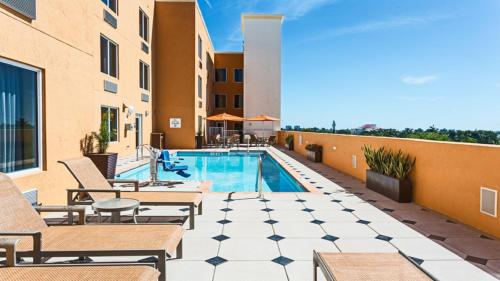 达尼亚滩劳德代尔堡机场南智选假日酒店的一个带游泳池和椅子的庭院和一座建筑