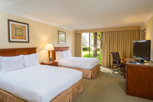 安大略Ontario Airport Hotel & Conference Center的酒店客房设有两张床和电视。