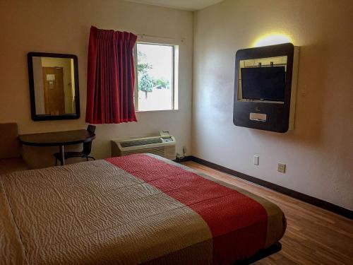 WoodwayMotel 6-Woodway, TX的酒店客房设有一张床和墙上的电视