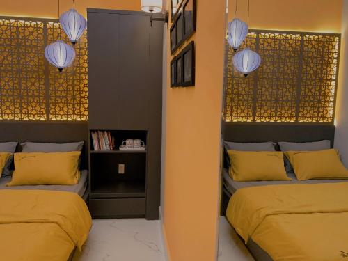 芹苴54 Homestay的配有黄色枕头和灯的客房内的两张床