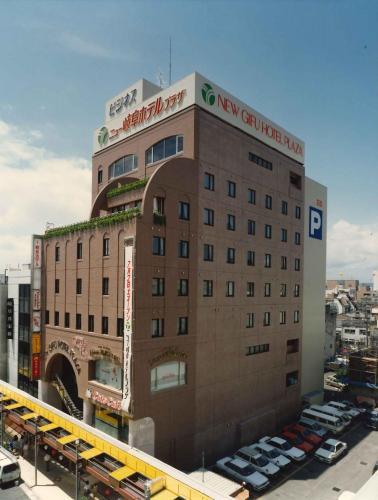 岐阜New Gifu Hotel Plaza的停车场内停放汽车的大型建筑