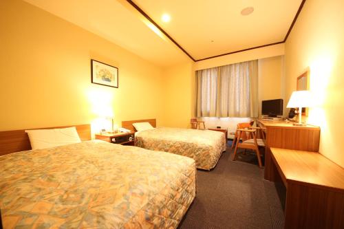 岐阜New Gifu Hotel Plaza的酒店客房配有两张床和一张书桌