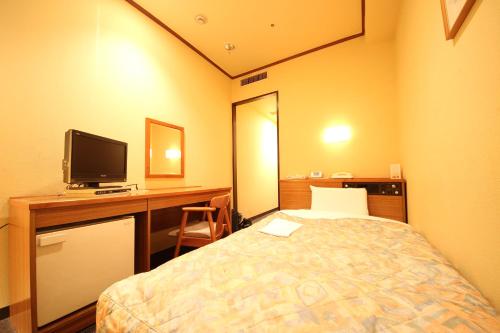 岐阜New Gifu Hotel Plaza的客房设有一张床、一张书桌和电视