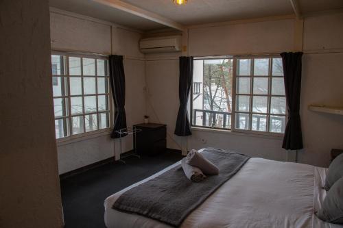 白马村粉寺酒店的一间卧室设有一张床和两个窗户。