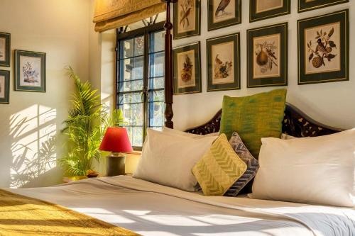 德拉敦Gorayya Villa的一间卧室配有一张带枕头的床,墙上挂有图片