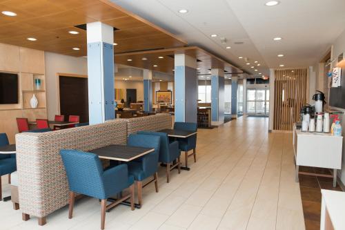 玛丽埃塔Holiday Inn Express & Suites - Marietta, an IHG Hotel的餐厅内带蓝色桌椅的用餐区