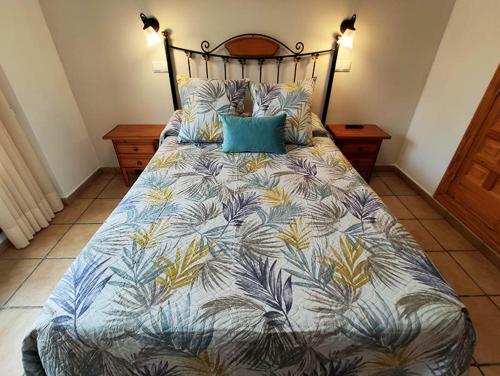 RoyuelaRoyuela Hostal的一间卧室配有一张蓝色和黄色的被子