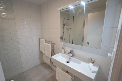 哈海Hahei Pavillion Guest House的白色的浴室设有水槽和镜子