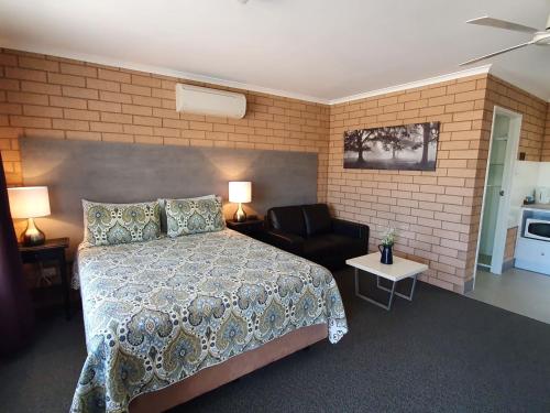 Streaky Bay斑斑海湾旅馆和别墅 的一间卧室配有一张床、一张沙发和一把椅子