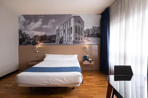 奥维多校园公寓酒店的一间卧室配有一张床,并拥有一栋建筑的照片