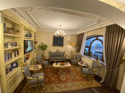 伊斯坦布尔暮烟套房酒店的客厅配有椅子和吊灯。