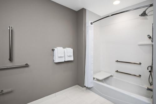 拉伯克Holiday Inn Express & Suites Lubbock Central - Univ Area, an IHG Hotel的白色的浴室设有浴缸和淋浴。
