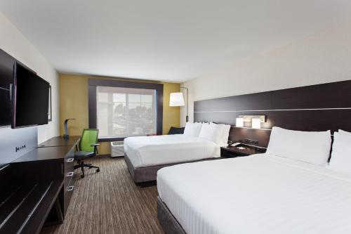 奥克兰Holiday Inn Express & Suites Oakland - Airport, an IHG Hotel的酒店客房设有两张床和一台平面电视。