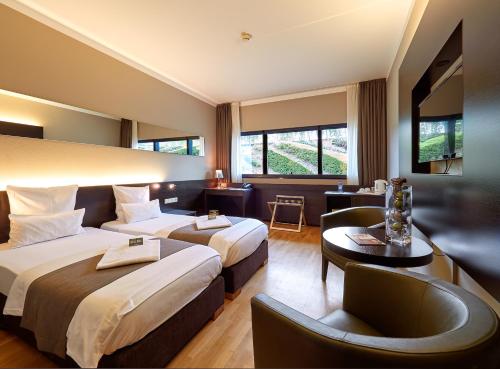 卢森堡d'Coque Hotel的酒店客房,设有两张床和一张沙发
