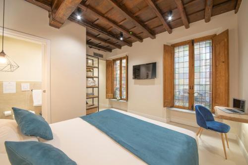 罗马Campo de' Fiori 34的一间卧室配有一张床和两张蓝色椅子