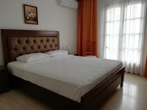 瓦西里亚斯天堂酒店的一间带一张大床的卧室,位于带窗户的房间内