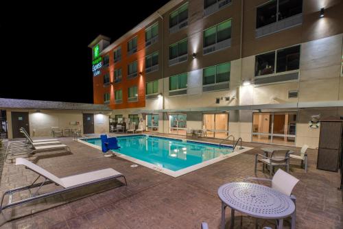 摩西莱克Holiday Inn Express & Suites - Moses Lake, an IHG Hotel的晚上在酒店前面的一个游泳池