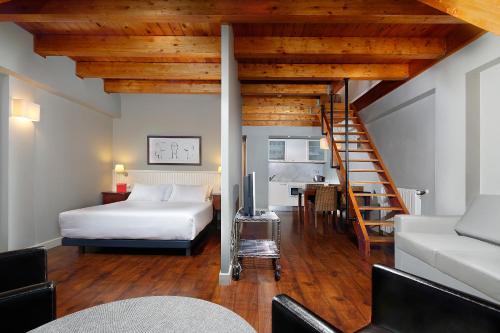 塞尔勒HG策尔勒公寓酒店的一间卧室配有一张床,房间设有楼梯