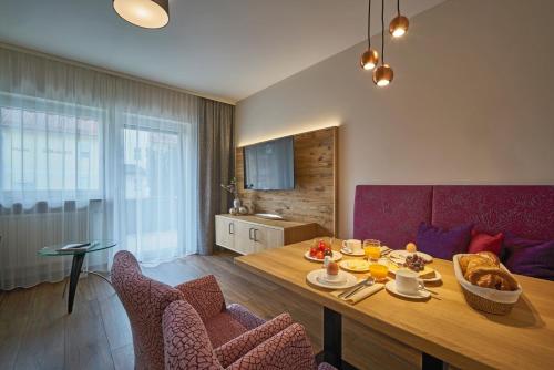 巴特法兴格Appartementhaus Absmeier的客厅配有桌子和红色沙发