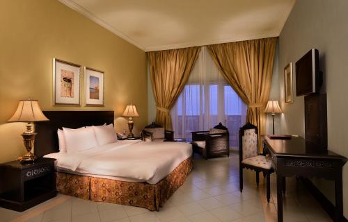 Ḩilf马斯拉岛度假酒店的配有一张床和一张书桌的酒店客房