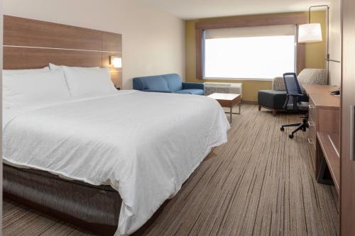吉尔伯特Holiday Inn Express & Suites - Gilbert - East Mesa, an IHG Hotel的酒店客房带一张大床和一把椅子